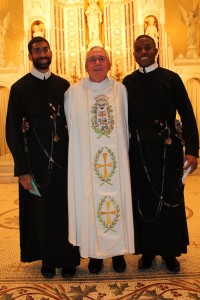 Seminarians David Verghese (left) and Jacky Merilan (right) pose with Rev. Kevin Moley (center) after a Mass celebrating their “perpetual confession,” a step in becoming priests in the Catholic Redemptorist Order, at Mission Church on Oct. 11. (Photo by Patrick E. O’Connor)