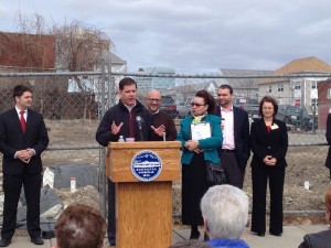 Mayor Martin Walsh (at podium) speaks at the senior housing groundbreaking March 29, joined by (from left) City Councilor Josh Zakim; state Rep. Jeffrey Sánchez; local activist Maria Sanchez; City Health and Human Services chief Felix G. Arroyo; and Wentworth Institute of Technology President Zorica Pantić. (Gazette Photo by Rebeca Oliveira)