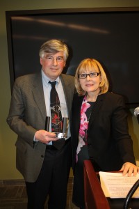 Jim Hoffman (left), the retiring director of Mission Hill Neighborhood Housing Services, receives a gift from his successor, Pat Flaherty, on April 6 at the organization’s annual meeting. Other well-wishers at the event included Mayor Martin Walsh, State Rep Jeffrey Sánchez and City Councilors Joshua Zakim and Ayanna Pressley. Hoffman led the nonprofit community development corporation for its 42-year history, with notable successes including the One Brigham Circle redevelopment. (Photo by Patrick E. O’Connor)